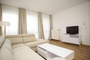 sala de estar con sofá blanco y TV en strandnah mit Terrasse, gratis Nutzung vom AHOI Erlebnisbad und Sauna in Sellin - Strandhaus Mönchgut FeWo06, en Lobbe