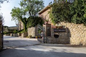 un edificio in pietra con un cancello su una strada di Hotel Villa Paradiso a Passignano sul Trasimeno