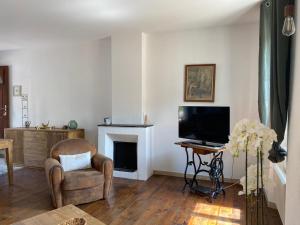a living room with a chair and a television at La Maison Des Vendangeurs in Villesèque-des-Corbières