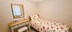 a small bedroom with a bed and a mirror at Mabel Cottage Sheringham in Sheringham