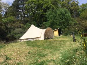 a tent sitting in a field in a field at EcoCamping d Hacadour in Mellionnec +44 photos