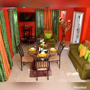 a living room with a table and a couch at Caribbean estate deluxe 2 in Portmore