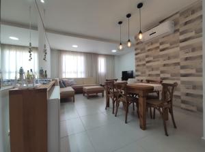 a dining room and living room with a table and chairs at Home Resort - Apto JPII48B Ubatuba in Ubatuba