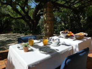 una mesa con un mantel blanco con comida y bebida en Domaine du Paradis des Oiseaux, en Mougins