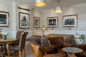 a waiting room with leather chairs and tables and pictures at Lakes Hotel & Spa in Bowness-on-Windermere