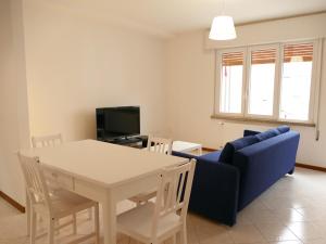 a living room with a table and a blue couch at CASA ADELE CAORLE in Caorle