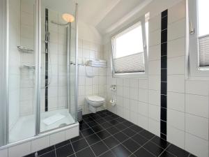 La salle de bains est pourvue de toilettes et d'une douche en verre. dans l'établissement Haus Kiehlwasser Whg 04 OG, à Boldixum