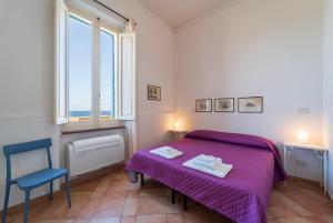 a bedroom with a bed, chair and a window at Palau Marco Polo in Alghero