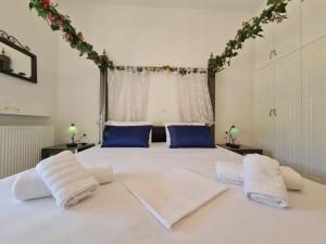 a bedroom with a large white bed with blue pillows at Myrtia Guest House in Pyrgos