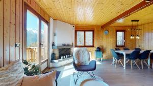 ein Wohnzimmer mit einem Tisch und Stühlen im Zimmer in der Unterkunft Charming chalet with a splendid view of the Valais mountains 