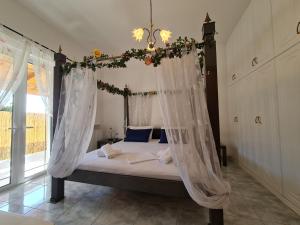 ein Schlafzimmer mit einem Himmelbett in der Unterkunft Myrtia Guest House in Pýrgos