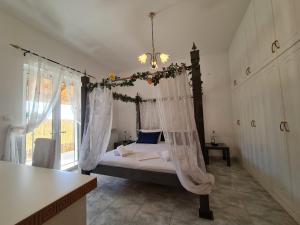 a bedroom with a bed with a mosquito net at Myrtia Guest House in Pýrgos