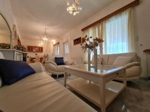 uma sala de estar com sofás e uma mesa com flores em Myrtia Guest House em Pirgos
