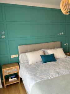 um quarto com uma cama com uma parede azul em Apartament Montsià em Sant Carles de la Ràpita