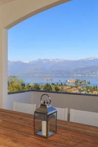 een tafel met uitzicht op het water en de bergen bij Lago 270 in Stresa