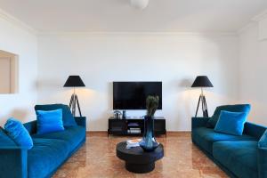 een woonkamer met twee blauwe banken en een tv bij Lago 270 in Stresa
