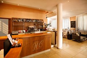 a kitchen with a bar and a living room at Hotel Hc Resort Lignano in Lignano Sabbiadoro