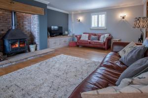 a living room with a couch and a fireplace at Highfield - 3 Bedroom Holiday Home - Llanmadoc in Llanmadoc
