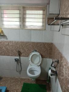 uma casa de banho com um WC e um chuveiro em Tavaru home stay em Ankola