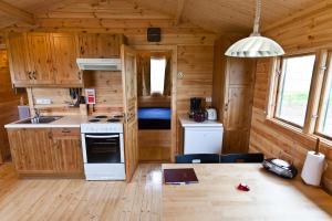 a kitchen and dining area of a tiny house at Mid Hvoll Cottages in Suður Hvoll