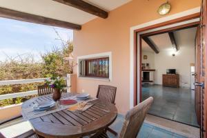 a dining room with a table and chairs and a balcony at Tonina vista mare in Capo Testa