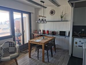 a kitchen with a wooden table and chairs in a kitchen at Appartement Torgon in Vionnaz