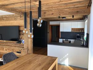 a kitchen and dining room with a wooden ceiling at Chalupa pod Ořechem in Rokytnice nad Jizerou