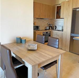 een keuken met een houten tafel en stoelen bij Kimata Sea View Apartment in Argassi