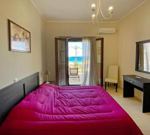 een slaapkamer met een groot roze bed en een bureau bij Kimata Sea View Apartment in Argassi