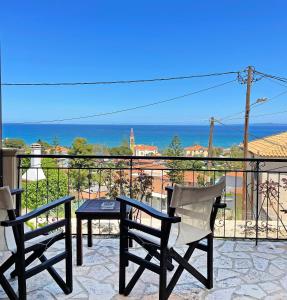 een patio met een tafel en 2 stoelen en de oceaan bij Kimata Sea View Apartment in Argassi