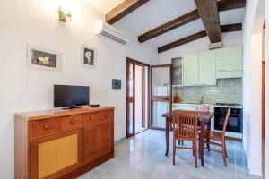 a kitchen and dining room with a table and a television at Appartamento Colomba in Capo Testa