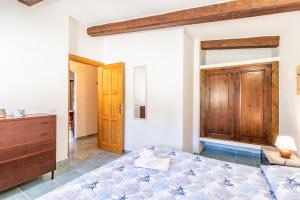 1 dormitorio con 1 cama y armario de madera en Appartamento Colomba, en Capo Testa