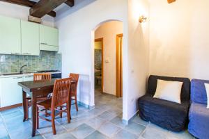 a kitchen and living room with a table and a couch at Appartamento Colomba in Capo Testa