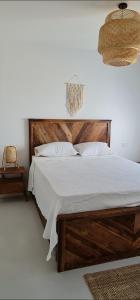 1 dormitorio con 1 cama grande y cabecero de madera en EL Gouna Swan Lake Apartment, en Hurghada