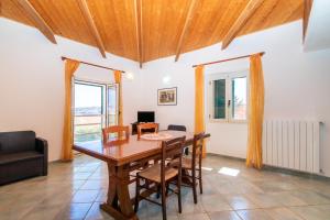 a dining room with a wooden table and chairs at Elisa Vista Mare in Capo Testa