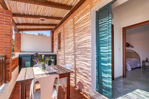 a patio with a table and chairs and a bedroom at Elisa Vista Mare in Capo Testa