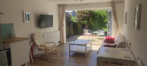 un soggiorno con divano e tavolo di Adorable One-Bedroom Flat With Patio Garden. a Southwick