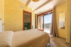 1 dormitorio con cama grande y ventana grande en Luxury Apartment Simius en Villasimius