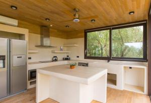 a kitchen with white counters and a large window at Villa Merilen in Develíkia