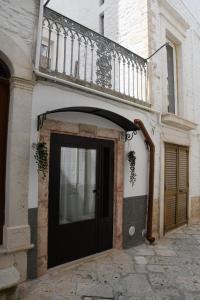un edificio con una puerta negra y un balcón en CASA VACANZE SANTA CROCE en Noci