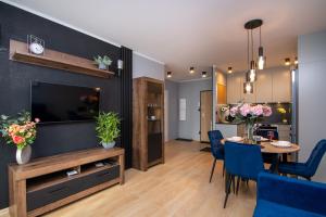 a living room with a television and a dining room at Maya's Flats & Resorts 50 - Aura 40 in Gdańsk