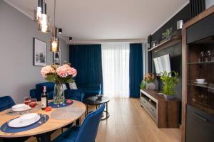 salon ze stołem i niebieskimi krzesłami w obiekcie Maya's Flats & Resorts 50 - Aura 40 w Gdańsku