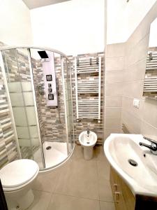 La salle de bains est pourvue d'une douche, de toilettes et d'un lavabo. dans l'établissement Lugaro Guest House, à Turin