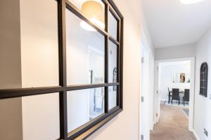 un pasillo con ventanas de marco negro en una casa en Velvet 2-bedroom apartment, Brewery Road, Hoddesdon, en Hoddesdon