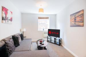 a living room with a couch and a tv at Velvet 2-bedroom apartment, Brewery Road, Hoddesdon in Hoddesdon +31 photos