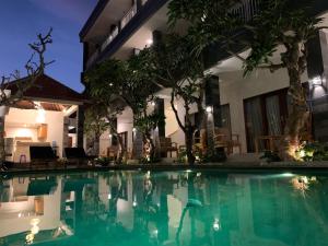 a swimming pool in front of a building at night at Sandat Living in Canggu