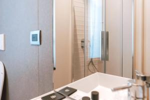 a bathroom with a shower and a white sink at BBCUBE in Porto Viro