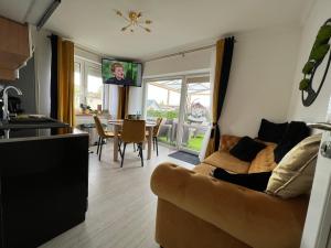 a kitchen and a living room with a couch and a table at Comfort Zone Ostróda Villa Apartment B in Ostróda