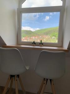 twee stoelen voor een raam met uitzicht bij Apartmán Frida in Nová Baňa