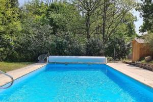 a large blue swimming pool in a yard at Jolie maison en pleine nature in Villiers-sous-Grez